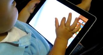 2-year-old Bridger wielding an Apple iPad as his parents videotape the action