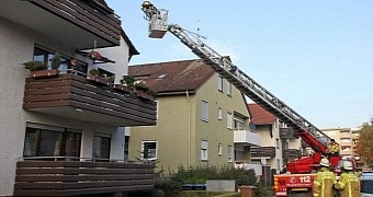 Photo shows the firefighters using a crane to get the man out of his apartment