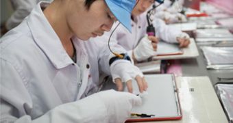 Workers at an Apple supplier facility in Shanghai assemble parts for the MacBook Pro