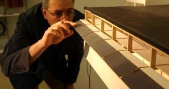 Ihab Elzeyadi, professor of architecture at the University of Oregon, looks at a model in his lab. The impact of exterior changes to block bright light and reduce energy consumption is being measured by a light meter inside the model
