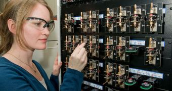 Argonne researcher Lynn Trahey loads a coin-sized cell on a testing unit used to evaluate electrochemical cycling performance in batteries