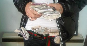 One of the silly drug dealers posed with handfuls of cash