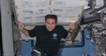 Greg Chamitoff, aboard the ISS, lifts huge zero-g stowage rack in Kibo Laboratory.