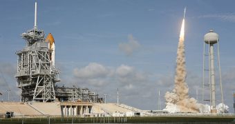 Atlantis rests at Launch Pad 39A while the prototype ARES I-X lifts off for its first test flight
