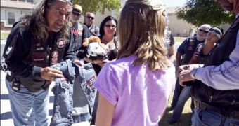 The biker rewards the young girl with a customized jacket for her bravery