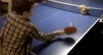 Boy plays ping-pong with his cat