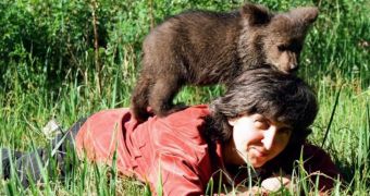 Woman looks after a bear cub as if it were her own child