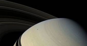 Image taken by Cassini showing Saturn, its rings, the moon Minas (upper left corner) and the shadow cast by Enceladus