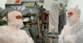 In the clean room housing Juno, NASA Administrator Charles Bolden is briefed by Lockheed Martin official Tim Gasparrini about the progress made thus far