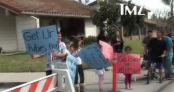 Children holding cardboard signs outside Nadya Suleman’s house