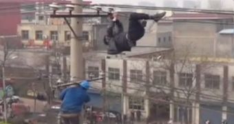 A drunk man dangles from electric lines
