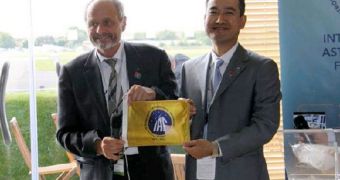 IAF president Berndt Feuerbacher and Shenzhou 7 taikonaut Zhai Zhigang are seen here holding one of 300 flags currently aboard the Tiangong 1 spacecraft