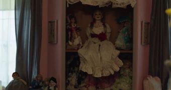 The Anabelle demon doll is placed on a shelf by a couple who doesn’t know better than to keep that thing in their house
