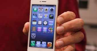 Consumer Reports reviewer holding the new iPhone 5 (white version)