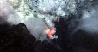 An explosion at the West Mata Volcano throws ash and rock, with molten lava glowing below