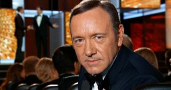 Kevin Spacey stares into the camera at the Emmys 2013, clearly hates it