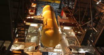 In the VAB, the external fuel tank, ET-134, is lowered between the twin solid rocket boosters already stacked on a mobile launcher platform