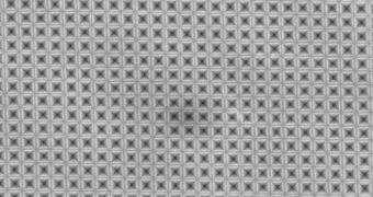 Seen from above, a sheet of silicon has been textured with an array of tiny inverted-pyramid shapes so small that they correspond to the wavelengths of light and can efficiently trap light waves