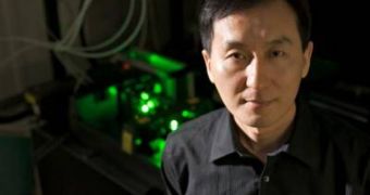 Chunlei Guo uses the femtosecond laser (behind him) to create nanostructures in metal that can move liquid uphill