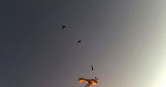 Skydiver looks up to see the burning plane