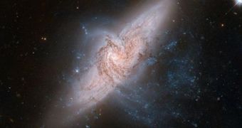 The closer, face-on galaxy is called NGC 3314A. Behind it lies the large spiral galaxy NGC 3314