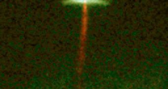 A reddish jet of gas emanates from the forming star HH-30, which is surrounded by a protoplanetary disk