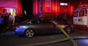 Firefighters stretch hose through BMW's windows