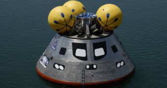 The mock-up Orion spacecraft is seen here floating in its test basin, with the three inflatable spheres on top
