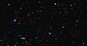 A deep view of a tiny patch of sky shows a selection of galaxies (red crosses) that were used in a new survey of the feeding habits of young galaxies as they grew through cosmic time