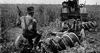 This photo from a 1921 encyclopedia shows a tractor ploughing an alfalfa field.