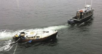 A boat gets towed away after being hit by a ferry