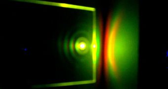 An LSC is illuminated by a laser beam, resulting in luminescence that is emitted from the edges and projected onto a business card. The faintly visible rings and different colors on the card result from microcavity effects