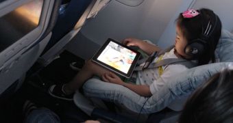 A kid using an iPad on a plane