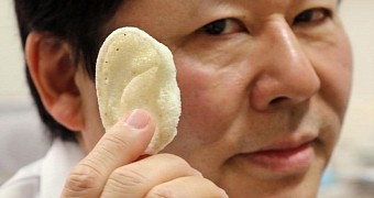 Professor Tsuyoshi Takato, holds up a prospective implant