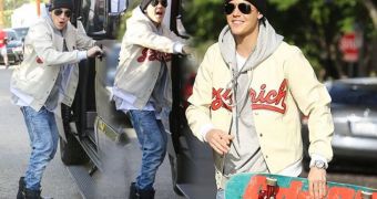 Justin Bieber holds on to the side of his van as he skateboards along it for a dangerous stunt