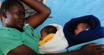New mother Millicent Owuor lies with her two sons, Obama and Romney