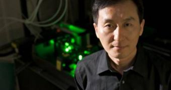 Chunlei Guo stands in front of his femtosecond laser, which can double the efficiency of a regular incandescent light bulb