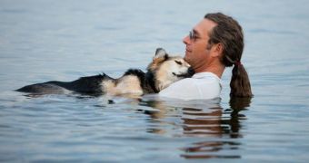 Man swims with dog to help ease the animal's pain