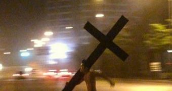 Man runs around Beijing carrying a cross
