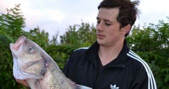 29-year-old Matthew Clark poses with the bass he pretended to catch for a contest