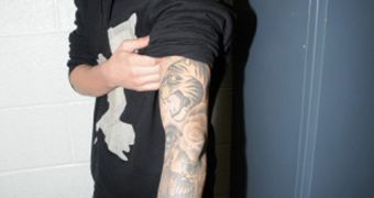 Justin Bieber shows off his tattoos to police cameras during his arrest