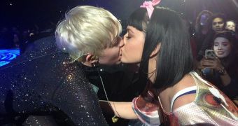 Miley Cyrus kisses a female fan during her concert, after she made out with Katy Perry last week