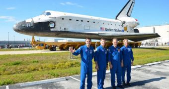 The STS-135 crew poses in front of shuttle Atlantis, while the spacecraft is moved to the KSC vehicle Assembly Building