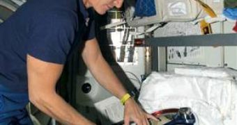 Space station commander Peggy Whitson checks her spacesuit