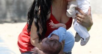 Nadya Suleman almost drops one of her infants as she tries to put on a show for the cameras, paparazzi say
