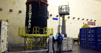 CryoSat-2 in the 'space head module' after being returned to the integration facilities. Two team members are babysitting the satellite until the launch campaign resumes