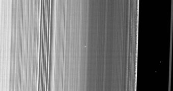 The new moonlet is visible towards the center of the image, casting its shadow on one of Saturn's main rings
