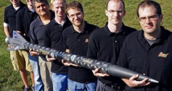 Team members holding the nine-foot rocket that was used to test ALICE