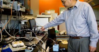 U-M associate professor Xudong Fan points to the compressor that is part of the smart, portable gas sensor that he is developing