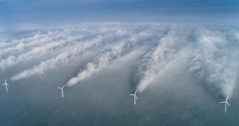 Normally invisible, wind wakes take shape in the clouds behind the Horns Rev offshore wind farm west of Denmark